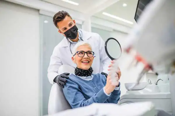 Beautiful senior woman with dental implants smiling in dental chair after having dental treatment at dentist's office at Coulter Family Dentistry in Spokane Valley, WA