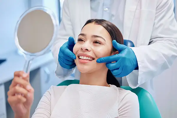 Smiling dental patient looking into mirror after dental cleaning at Coulter Family Dentistry in Spokane Valley, WA