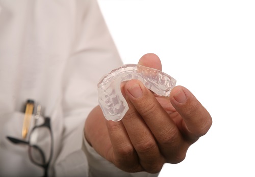 Dentist holding a mouthguard from Coulter Family Dentistry 