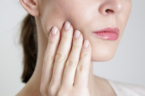 Woman with bruxism pressing at her aching jaw at Coulter Family Dentistry in Spokane Valley, WA